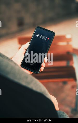 Mature woman receiving new message notification on smartphone. Texting, mobile technology use among older adults, and staying connected through phone. Stock Photo