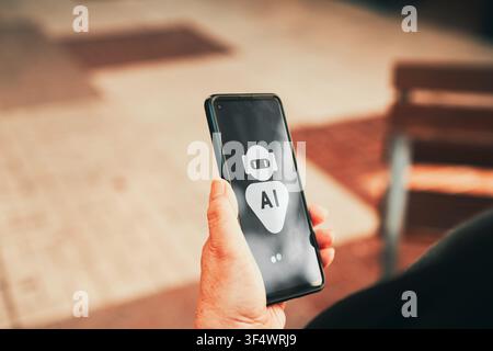 Mature woman using AI chatbot assistant on smartphone outdoors. AI technology adoption, digital assistants, and mobile innovation among older adults. Stock Photo