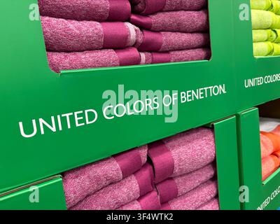 Stacked colorful beach towels in retail packaging featuring United Colors of Benetton branding. Stock Photo