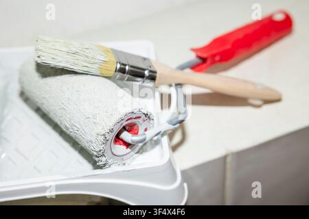 Paint roller and brush with white paint tray for interior wall renovation. Concept: DIY improvement Stock Photo