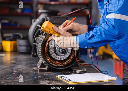 Electrical Maintenance Motor. Technician at Work measuring power meter with Electric motor in modern heavy EV car industry Stock Photo