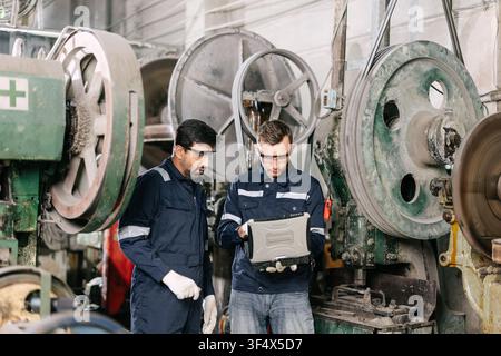 Professional Engineer technician workers monitor at laptop computer service machine in heavy industry factory Stock Photo
