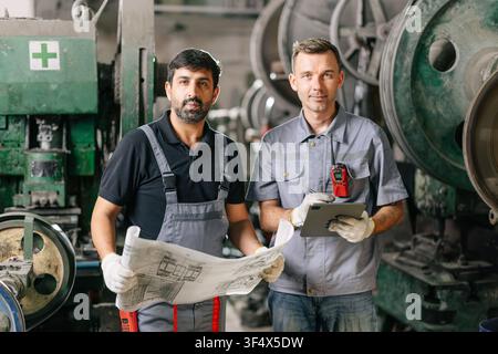 Portrait Engineer Male Workers team standing together in Machinery Workshop. Heavy Industry technician people mix race looking camera. Stock Photo