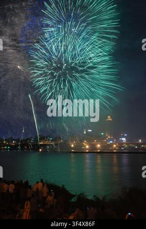 Vibrant green fireworks illuminating the night sky over Tamsui River in Taipei, Taiwan Stock Photo