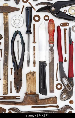 Flat lay of old hand tools on white background. Large collection of various rusty tools and bits arranged on white. Stock Photo