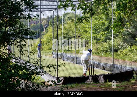Young people using public nets for cricket practice, London, UK Stock Photo
