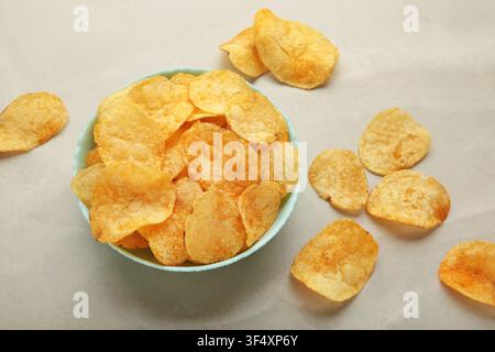 Delicious potato chips in bowl on light grey background. Top view Stock Photo