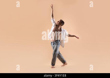 Professional dancer practicing moves on beige background Stock Photo