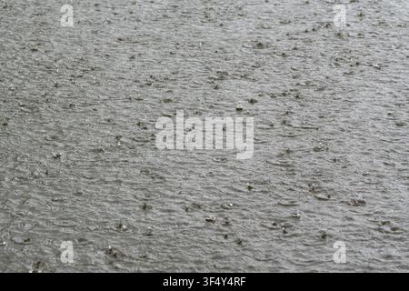 heavy rain falling onto a large body of water Stock Photo