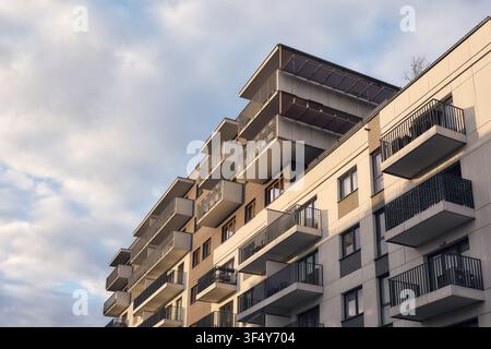 Modern apartment building with repeating balconies in warm late afternoon light, representing contemporary urban housing and real estate. Stock Photo