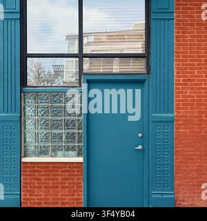 Blue entrance door beside glass block windows on a historic red brick building in Chicago. Stock Photo