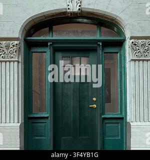 Green door beneath a stone arch with on a historic building in Chicago, Stock Photo