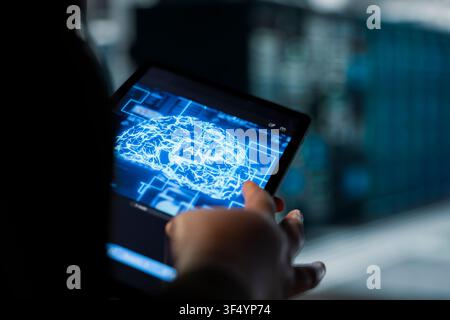 Closeup of engineer using neural networks in data center to track metrics of gear used to host websites. Server hub worker uses deep learning AI assistant to upgrade rigs running companies databases Stock Photo