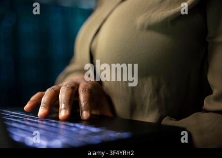 Close up of data center technician conducting tests on equipment using laptop software to fix bugs. Server farm worker using notebook to refine algorithms for faster processing, updating core services Stock Photo