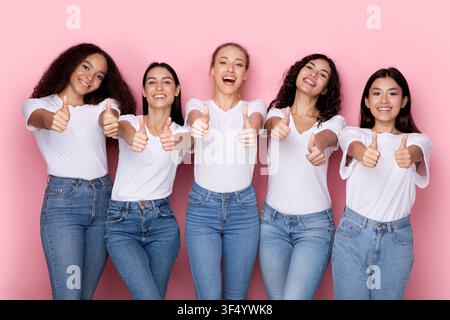 Multiethnic Females Showing Like Gestures With Both Hands, Pink Background Stock Photo