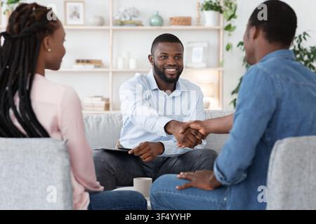 Thankful Black Couple And Marital Therapist Shaking Hands After Successful Meeting Stock Photo