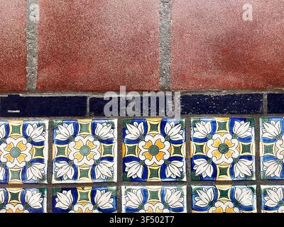 View from above of brown Saltillo tiles along with flowery tiles. Stock Photo
