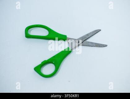Hand Holding Green Plastic Handled Scissors Isolated on White Background Stock Photo