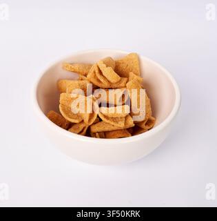 Crunchy cone shaped corn chips in a ceramic bowl isolated on white background Stock Photo