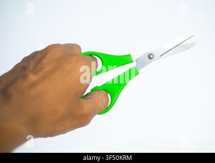 Hand Holding Green Plastic Handled Scissors Isolated on White Background Stock Photo