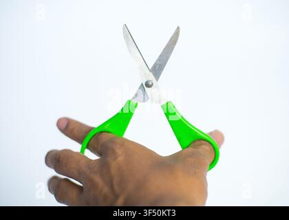 Hand Holding Green Plastic Handled Scissors Isolated on White Background Stock Photo