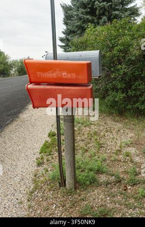 A traditional rural mailbox featuring a bright red newspaper delivery tube. Symbolic of the death of print. Stock Photo