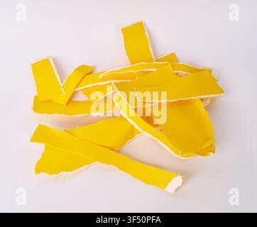 Pile of assorted torn yellow paper strips isolated on white background Stock Photo