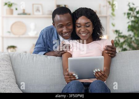 Happy lovers using digital tablet, checking new application Stock Photo