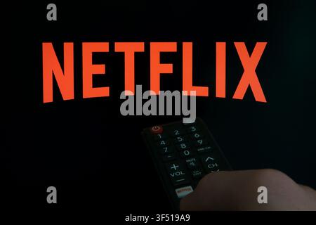 March 22, 2024: A Netflix streaming service company logo is shown displayed on a TV screen and a shortcut button on a remote control. Stock Photo