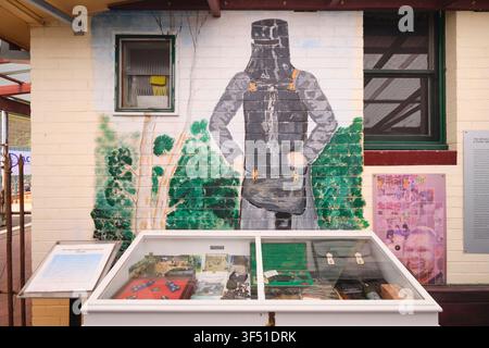 Various jail guard objects with a Ned Kelly painting on the wall. At the Corrective Services NSW Prison Museum in Cooma, Australia. Stock Photo