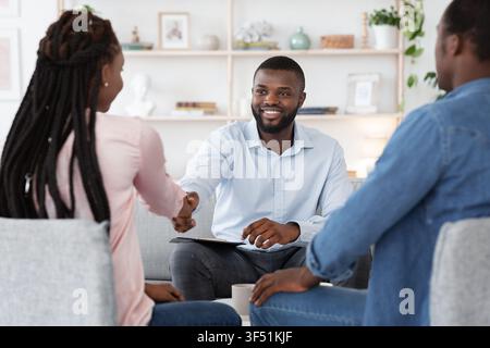 Family Counselor Shaking Hands With Happy Black Couple After Successful Therapy Stock Photo