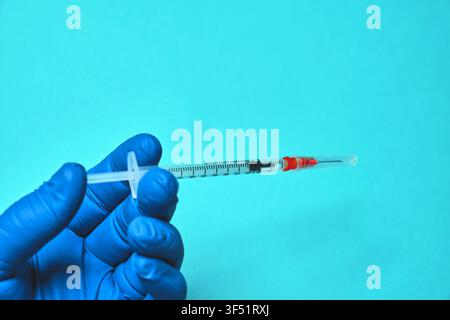 Hand in medical glove holding a glp-1 medication syringe Stock Photo