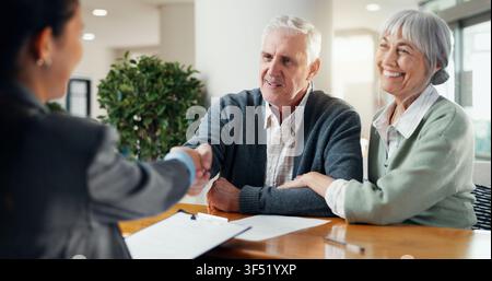 Smile, old couple and handshake at house with advisor, real estate deal and purchase agreement. Senior people, shaking hands or thank you for Stock Photo