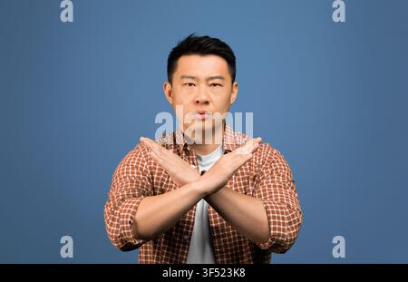 Man Standing With Arms Crossed, Serious Expression, Studio Background, Business Concept Stock Photo