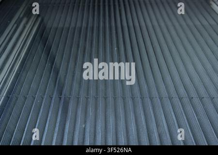 An extreme close-up of a pleated mosquito net on a window reveals fine vertical mesh folds in cool gray-blue tones, with subtle light passing through Stock Photo