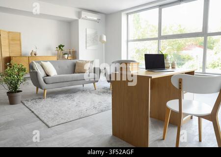 Interior of living room with programmers desk, sofa and armchair Stock Photo