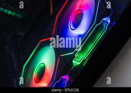 Vibrant RGB fans illuminate a custom gaming PC interior, showcasing multicolor LED lighting, airflow-focused cooling components and modern hardware de Stock Photo