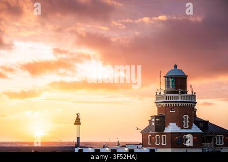 Helsingborg lighthouse and pilot station on the Parapeten pier in the harbor in beautiful warm summer sunset with colorful clouds over the horizon Stock Photo