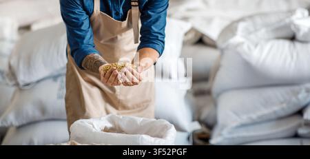 Male Worker Holding Grain In Warehouse, Focused On Quality Control, Business Concept Stock Photo