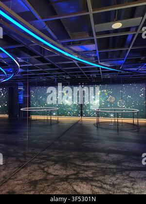 Modern science exhibition room with space theme large digital screen displaying deep universe stars and neon lighting installations Stock Photo