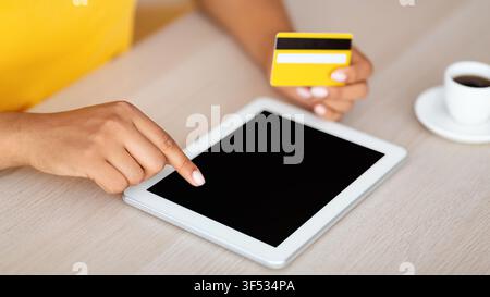 Black woman using tablet with mockup and credit card Stock Photo