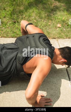Man doing push ups outside wearing a weighted vest Stock Photo