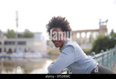 Happy Black woman with an afro smiling outdoors Stock Photo