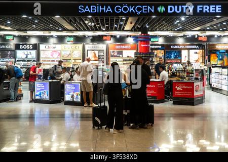 Travelers browse duty-free shops at Sabiha Gökçen Airport in Istanbul, Turkey. Stock Photo