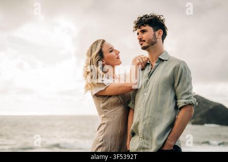 Romantic young couple standing together by the ocean Stock Photo