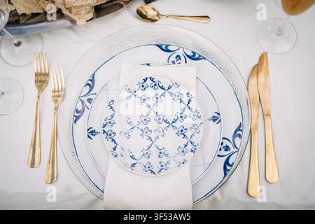Elegant blue and white table setting with gold cutlery Stock Photo
