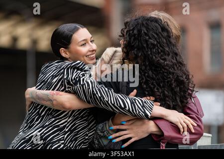 Happy group of diverse friends hugging outdoors Stock Photo
