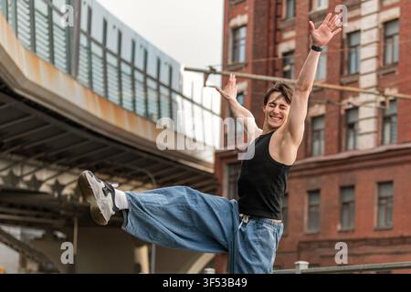 Joyful  man is dancing energetically on a city street. Stock Photo