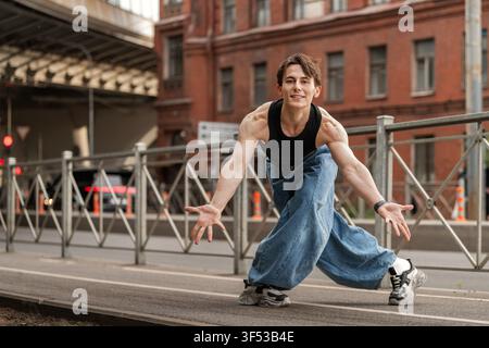 Young man in baggy jeans dancing on a city street Stock Photo