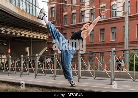 Smiling  man is dancing energetically on a city street. Stock Photo